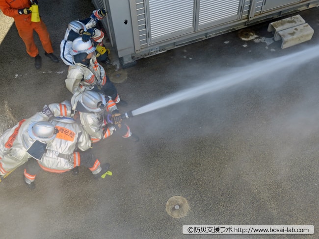 強風下での放水中。京都の消防士の活動写真。