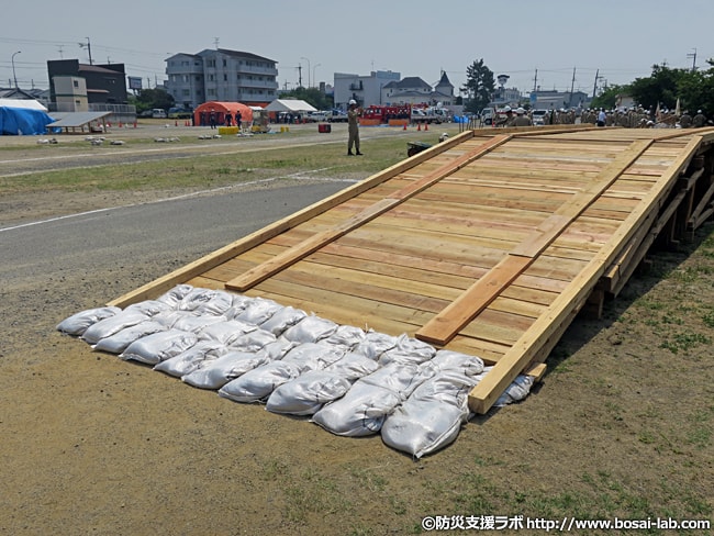 岸和田市の水防団による仮設橋が完成。進入口と退出口には土のうが設置されています。