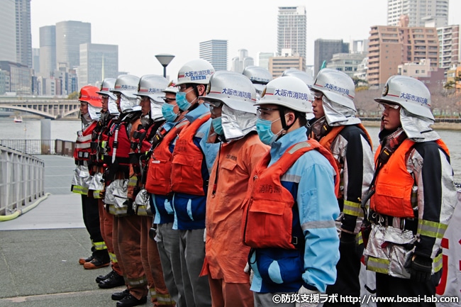 1日消防署長、西川忠志さんへの船舶火災総合訓練終了報告。